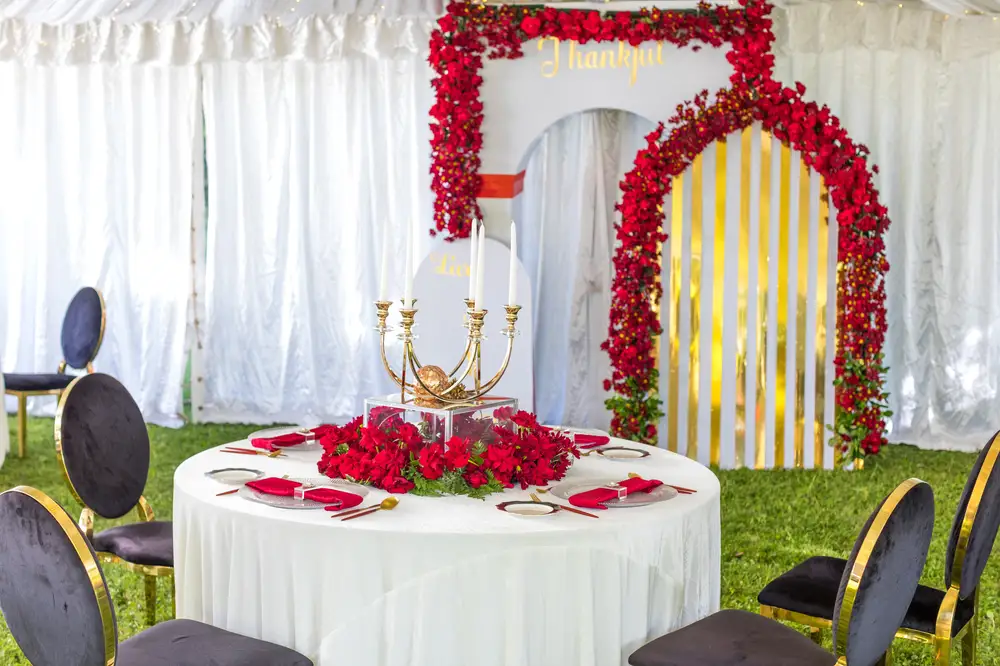 Round White table at an event Centre decorated with red roses with