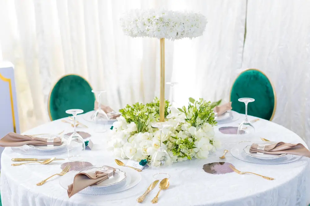 Round table decorated with flowers and cutlery