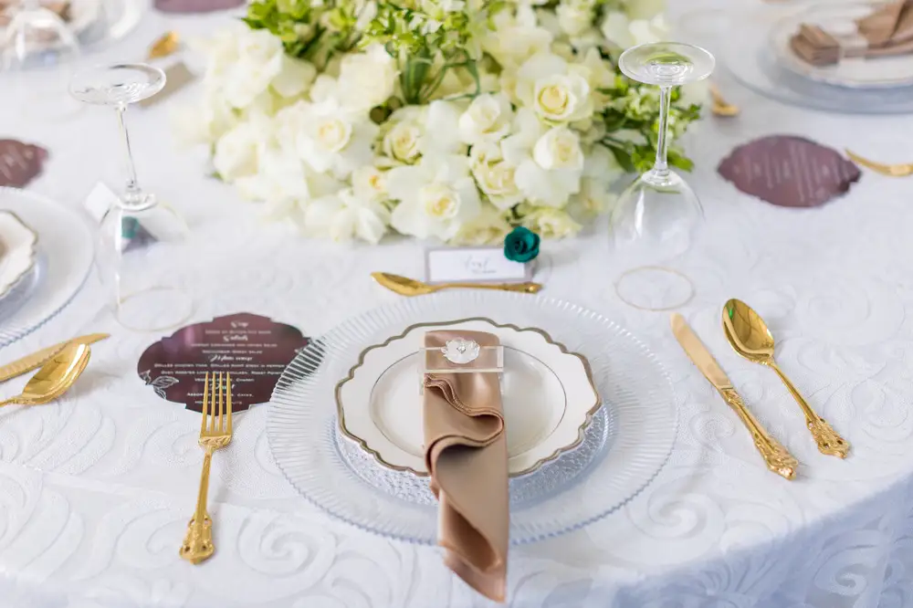 Napkin in a white dish with golden cutlery