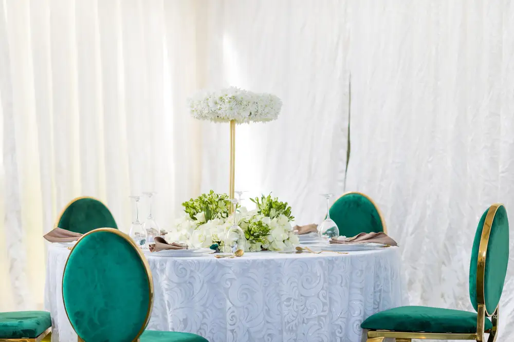 White flowers and green chairs on a dinning table