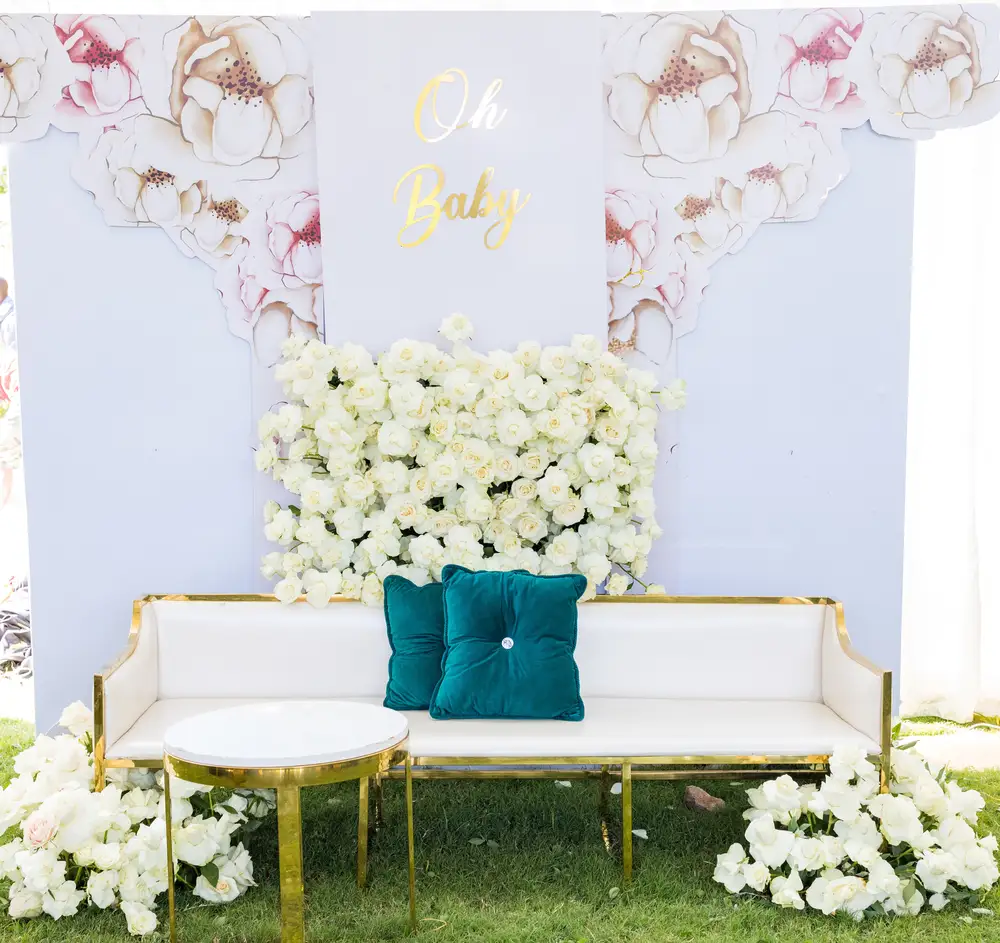 Long white couch and a backdrop decorated with flowers