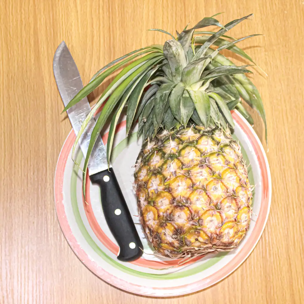 Pineapple on a Ceramic plate with a Knife