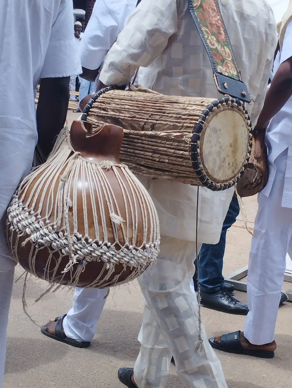A Man Carrying Beaded Gourd Rattle and Talking drum