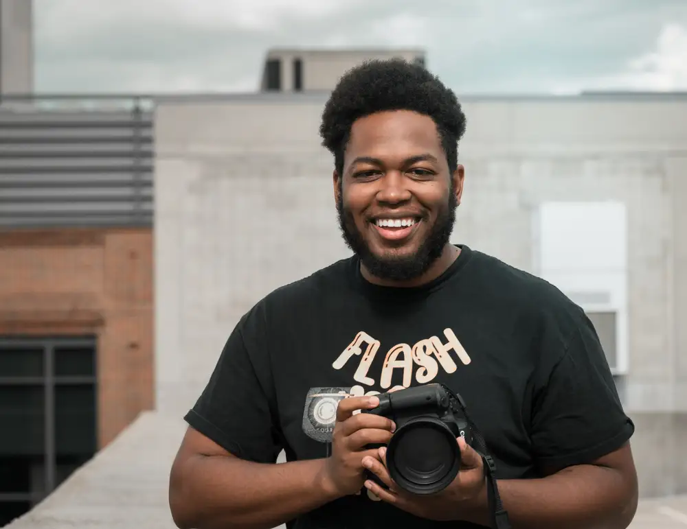 man holding a camera and smiling
