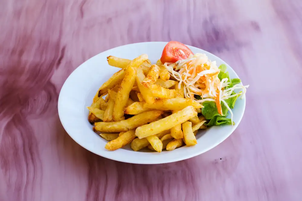 Plate of French fries with vegetables
