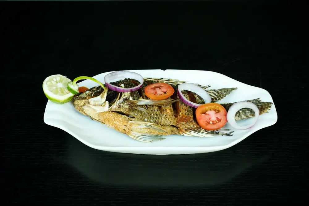 Fried tilapia fish and vegetables on a plate