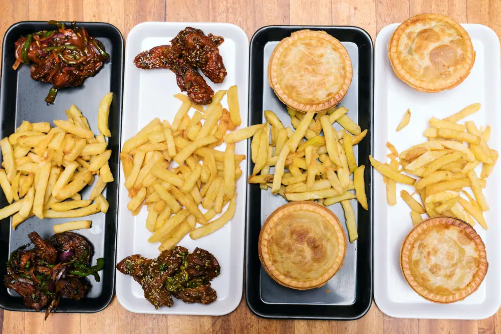 Trays of french fries with pie and meat