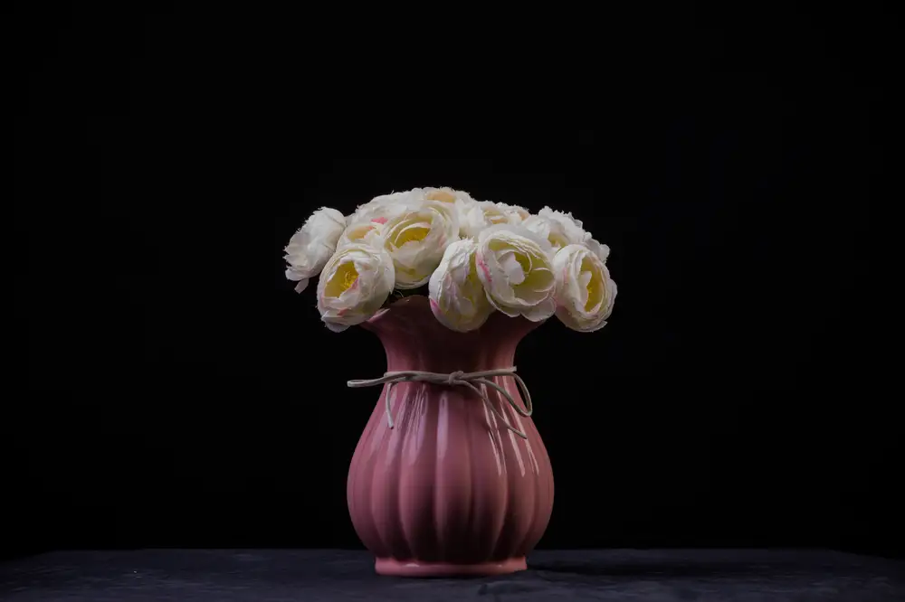 Pink flower vase containing Blooming white flowers
