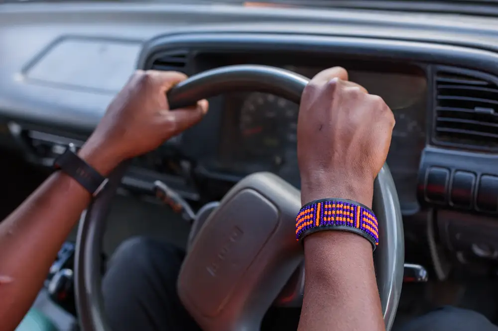 Man wearing a bracelet and driving a car