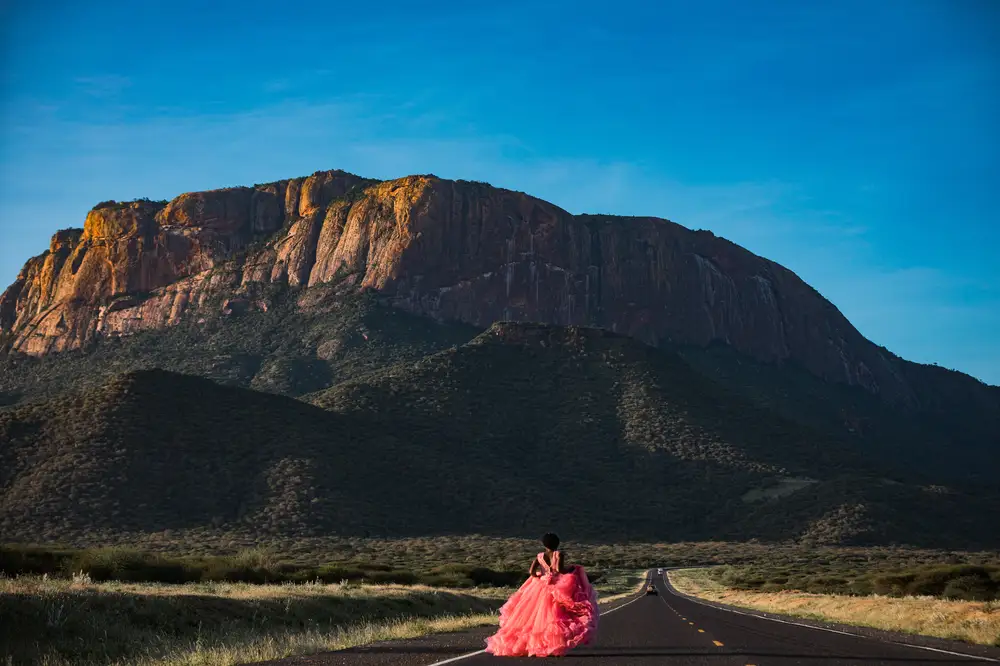 Lady in Pink dress running towards a mountain