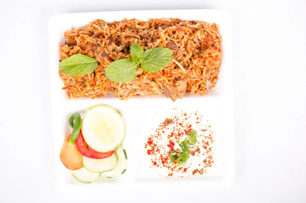 Jollof rice with cucumber served for lunch