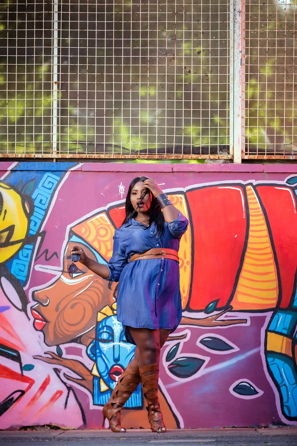 Woman posing in front of graffiti wall art
