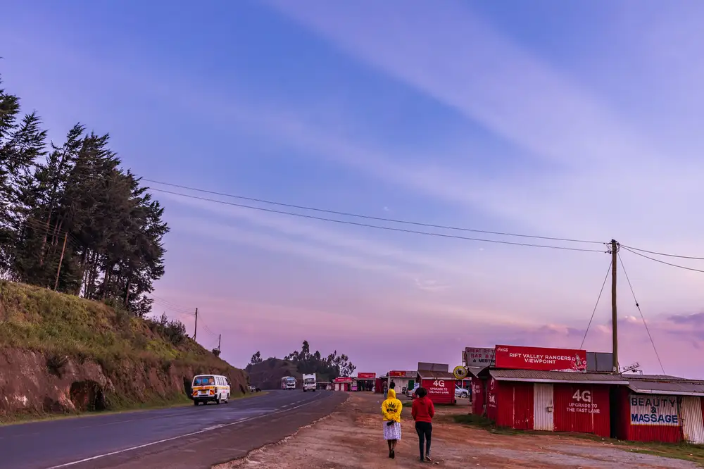 People and vehicles on the road at dawn