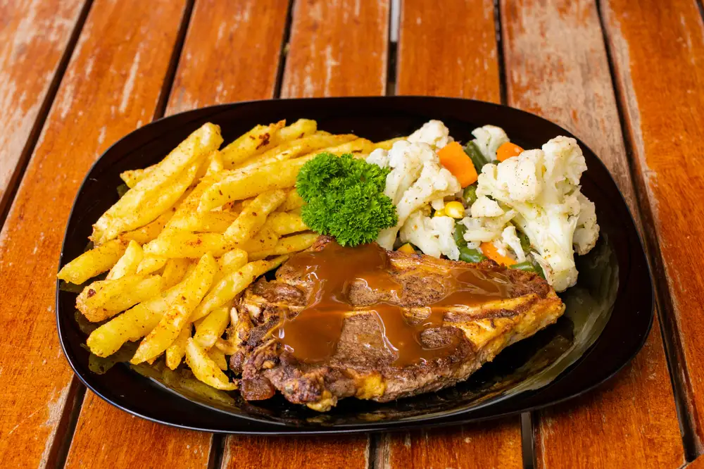 Vegetables and sauce served with French fries,