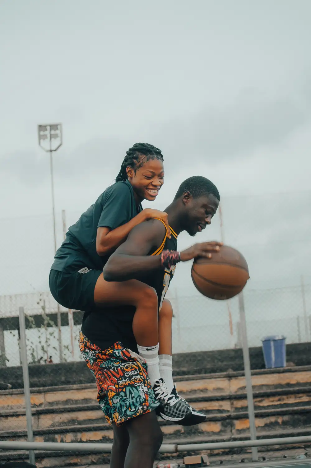 man piggybacking a woman on a basketball court