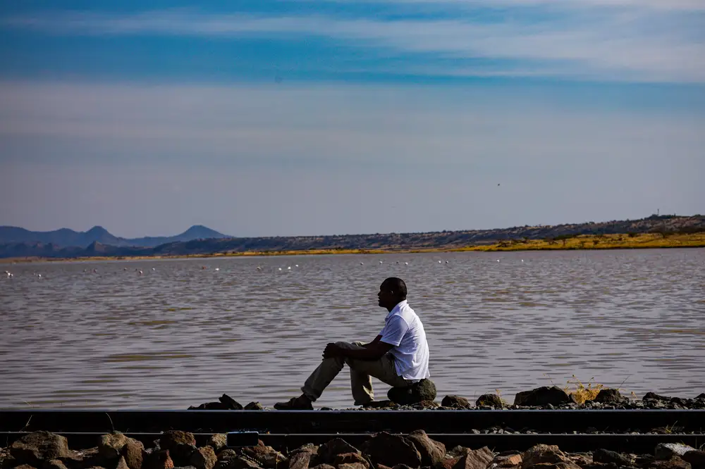 Man sitting on a rock beside a lake