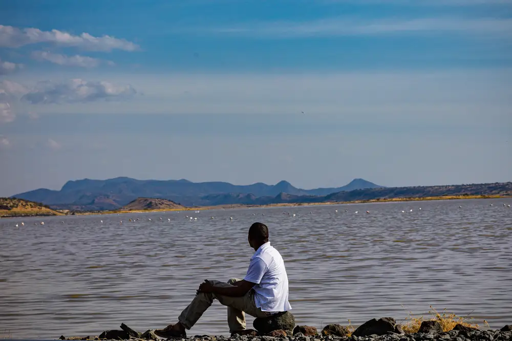 Man sitting beside a river