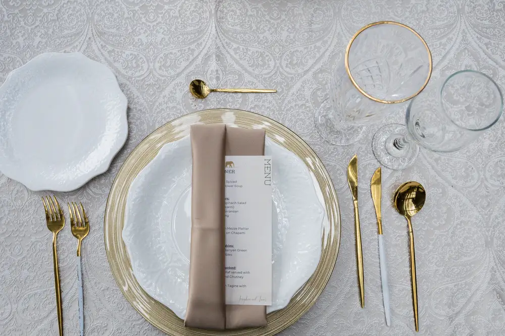 Food Menu placed in a ceramic plate with golden cutlery