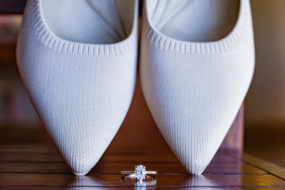 Pointy White female shoes with a diamond ring