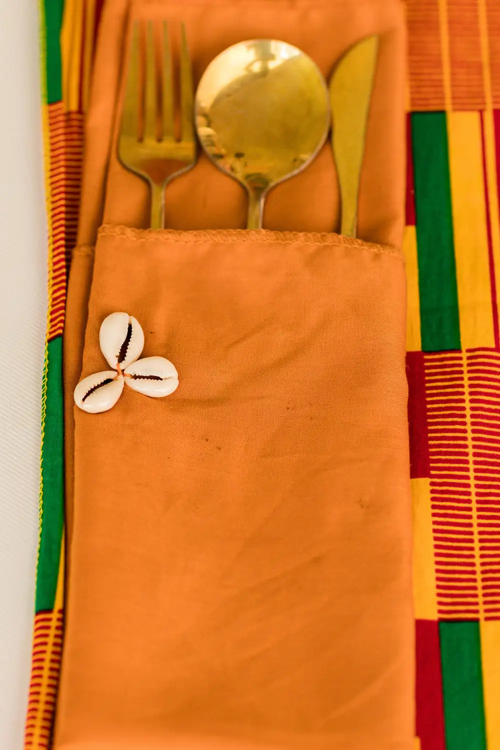 Cowry decorated pouch with  golden spoon and fork