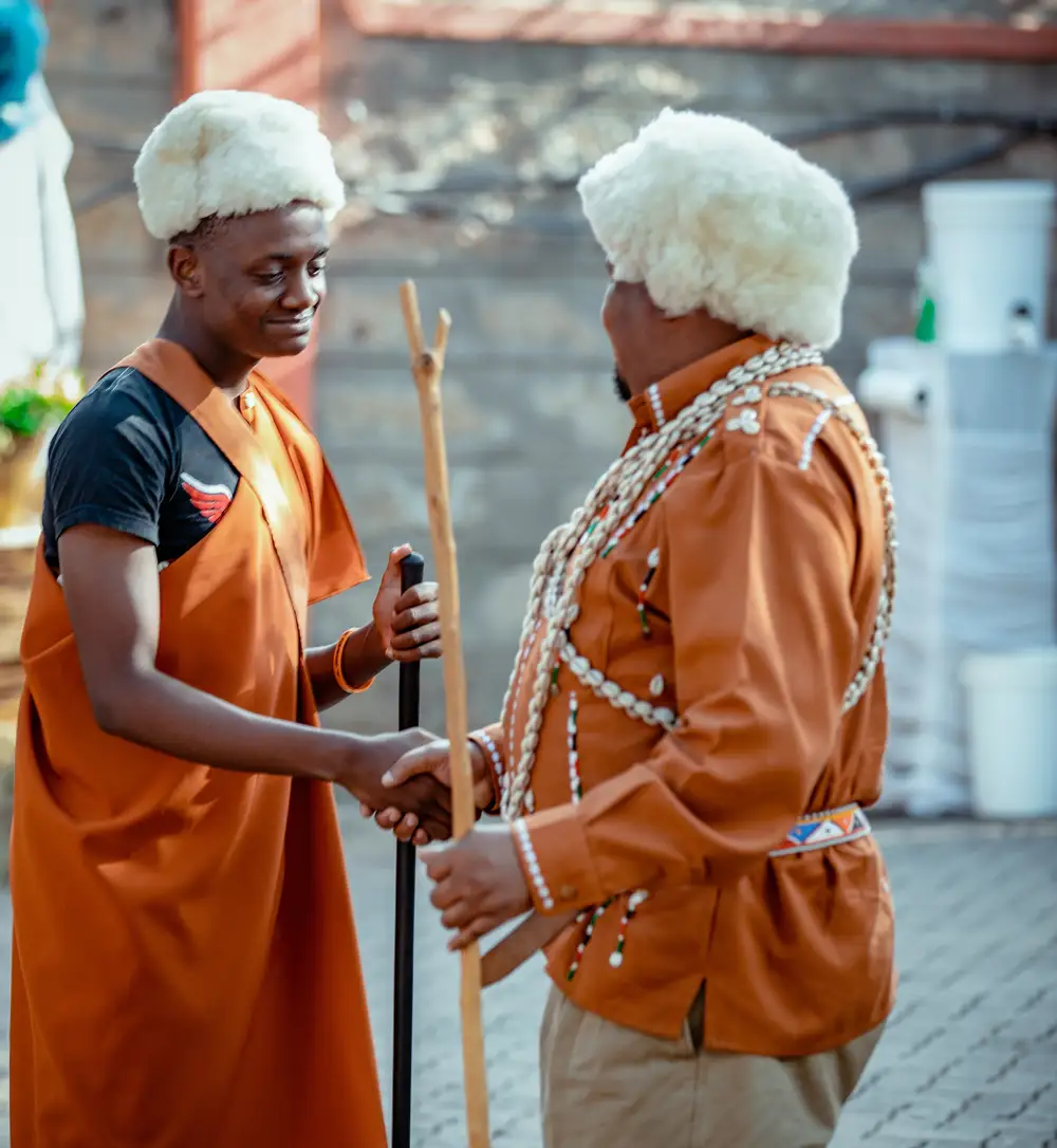 Old men in traditional attire shaking hands