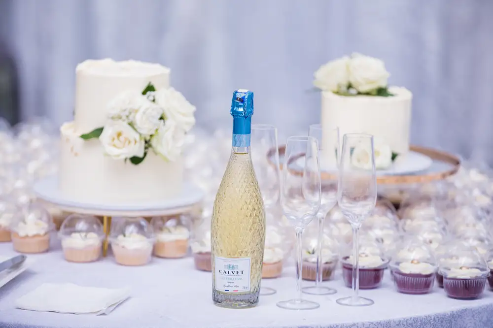 White wedding cakes with a bottle of wine