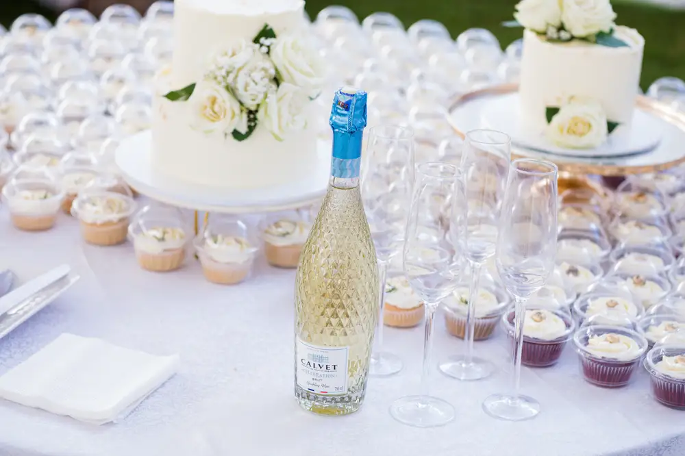 Weddingg Cakes and cupcakes with a bottle of Wiine