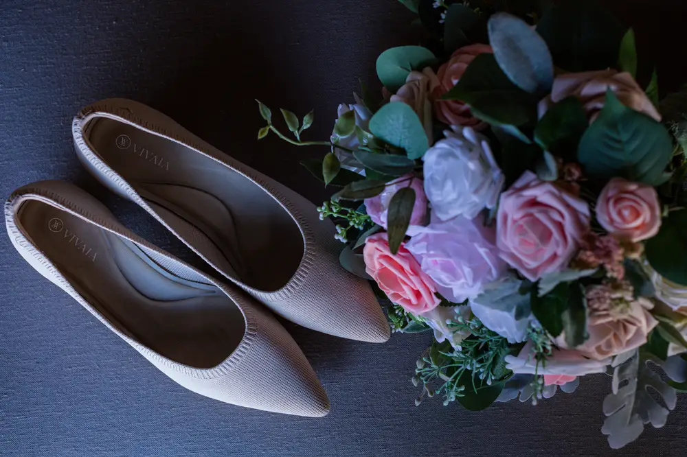 Pointy White Female Wedding shoes with a bouquet of Flowers