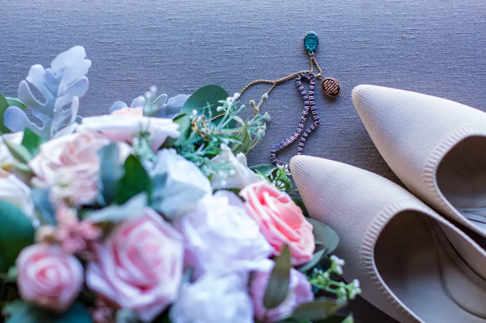 Pointy White Female Wedding shoes with a bouquet of Flowers
