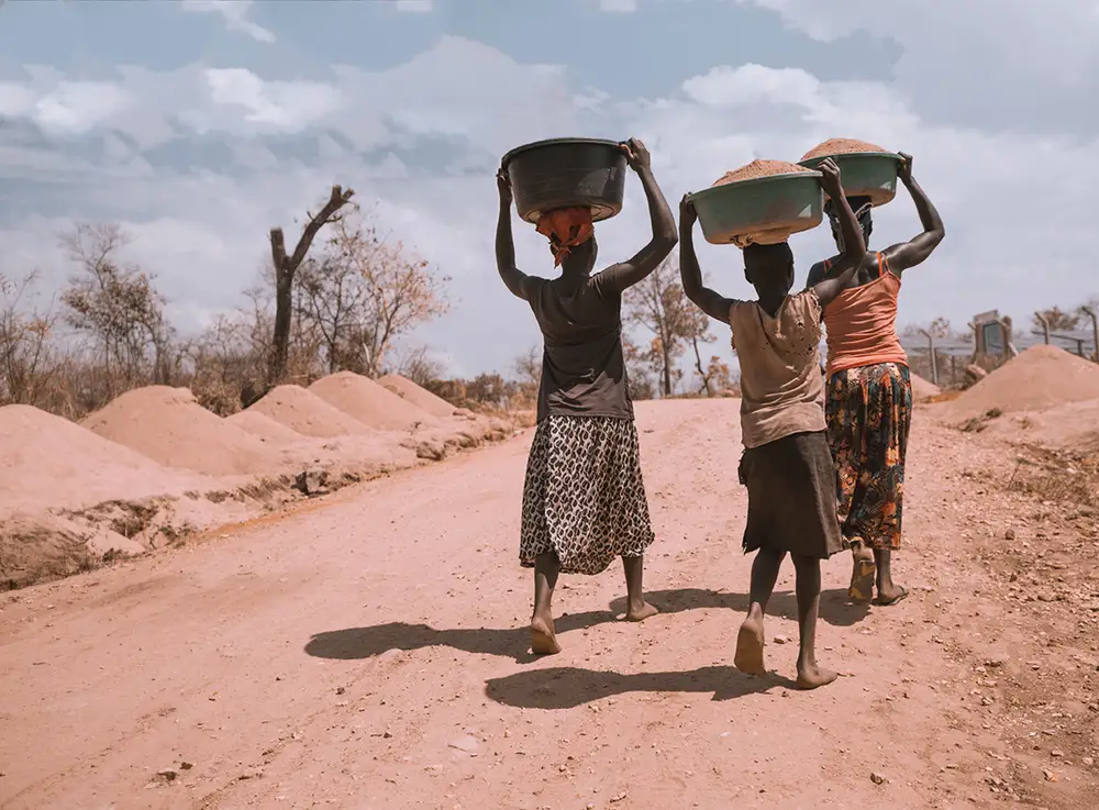 women carrying sand