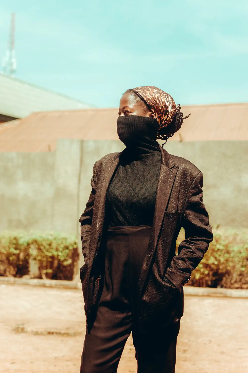 Lady wearing a brown suit with face covered Lookin sideways
