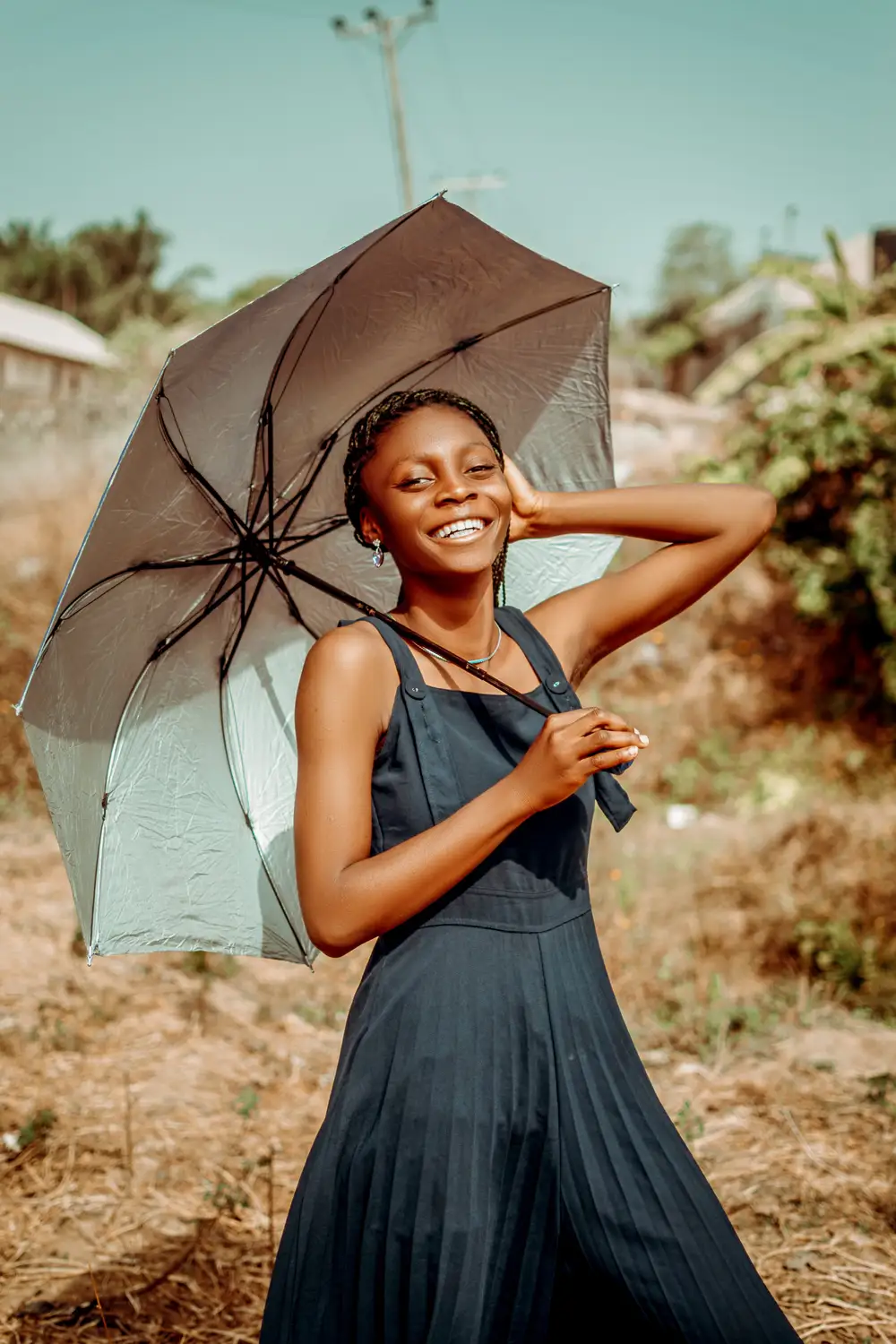 Smiling Young girl posing with an umbrella wearing a black dress
