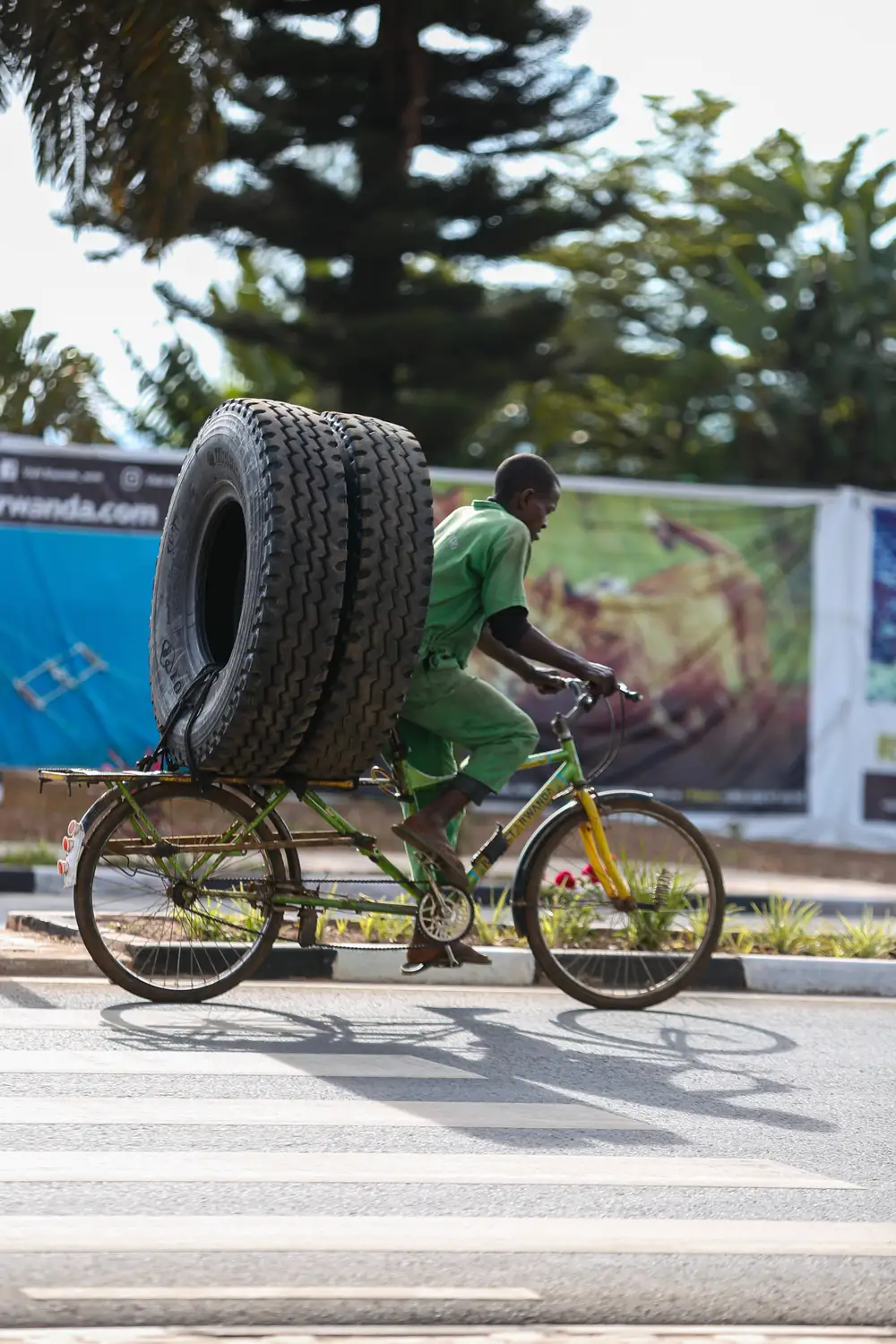 man carrying tyres with bicycles