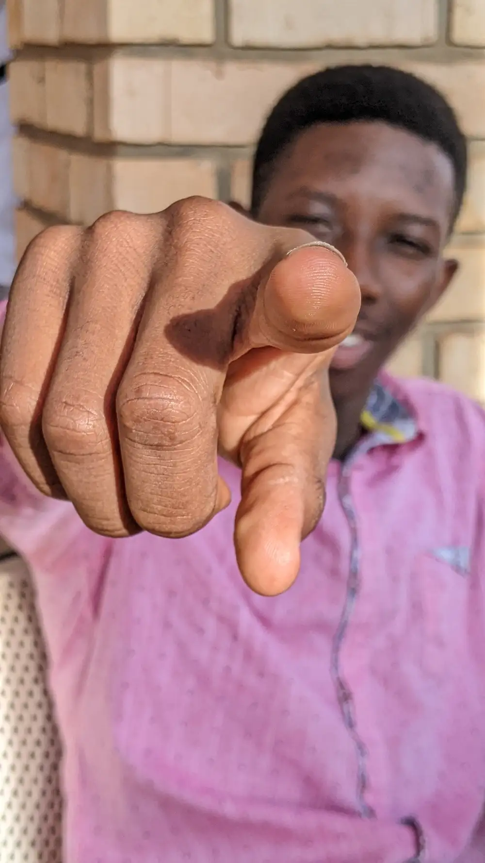 Young African pointing a finger into a camera.