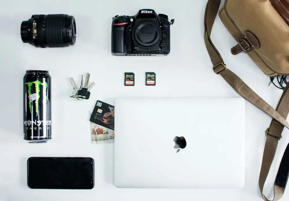 A laptop, camera, bag and key on a table