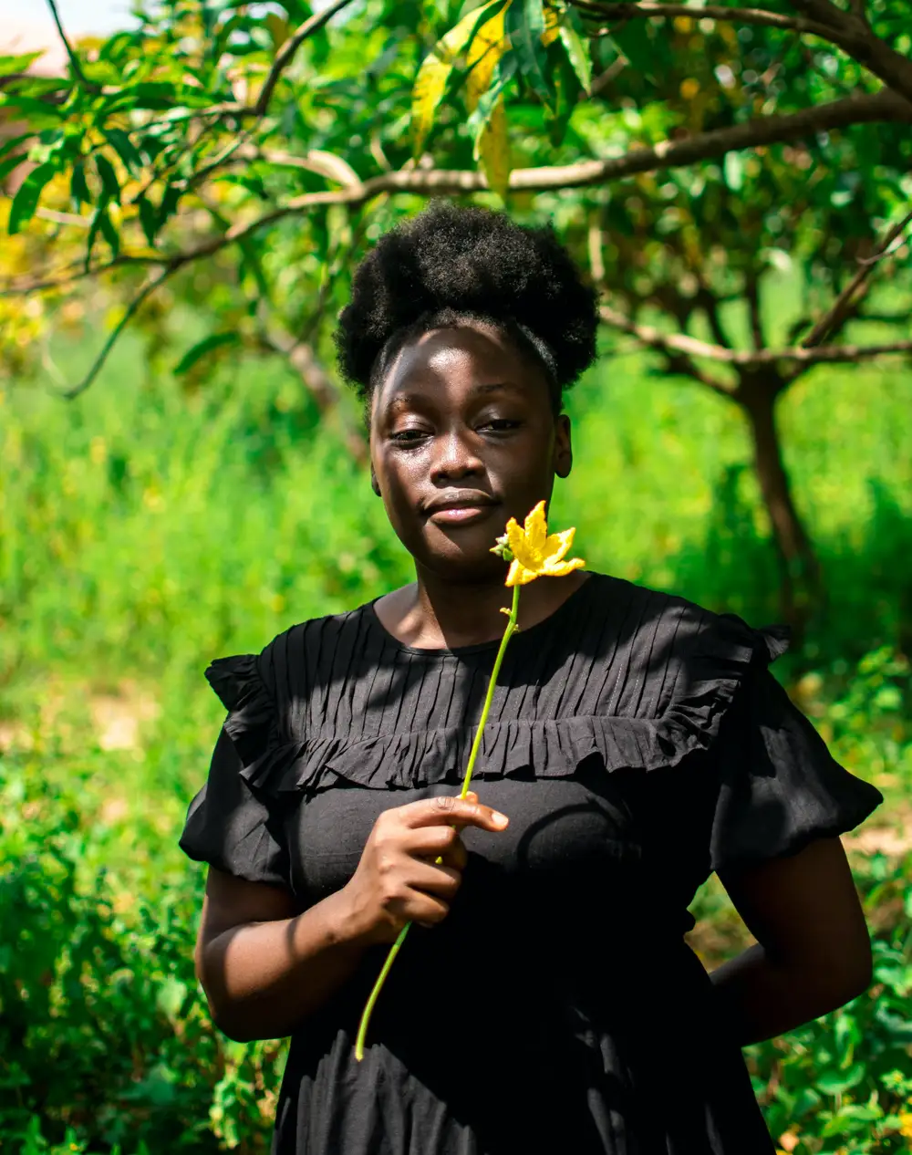 Lading on black gown holding one flower