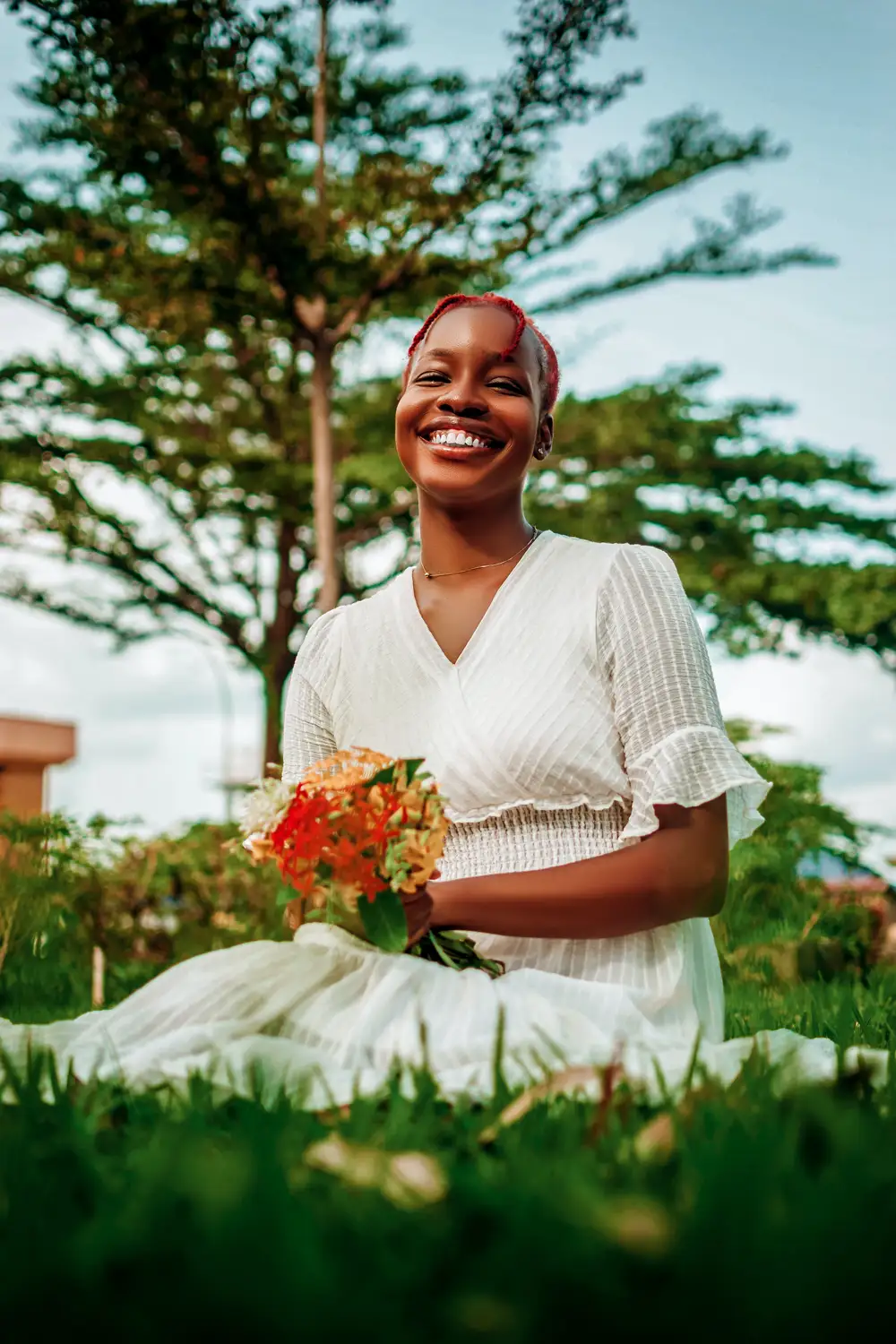 Lady sitting on grass holding flowers