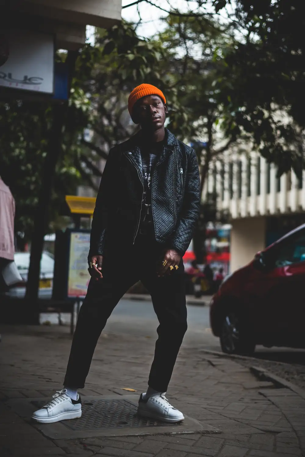 Man in black jacket standing beside road photo