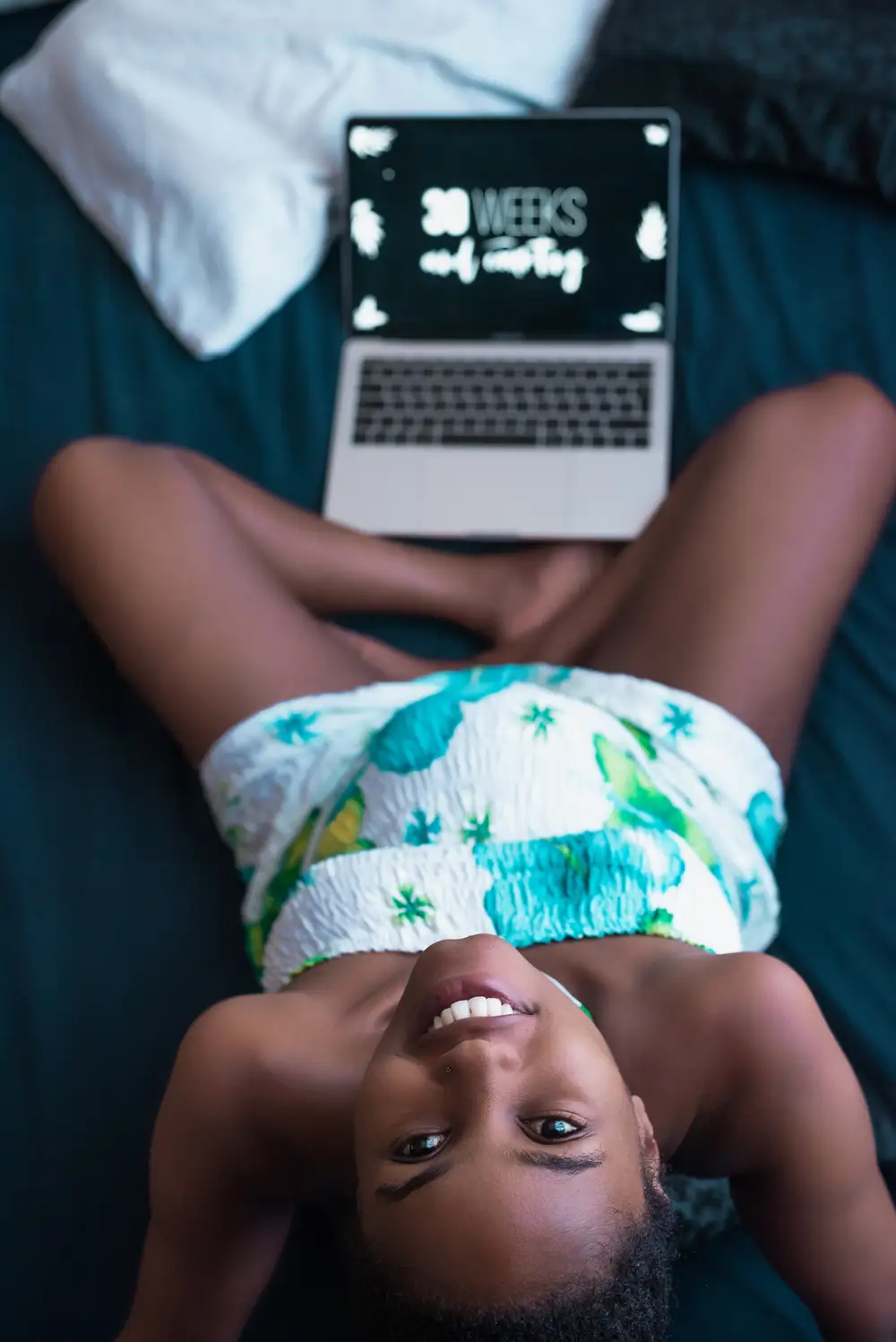 Pregnant woman beside a turned-on laptop screen Kenya