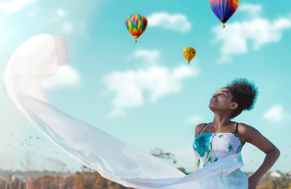 Woman in white and green dress standing with hot air baloons photo