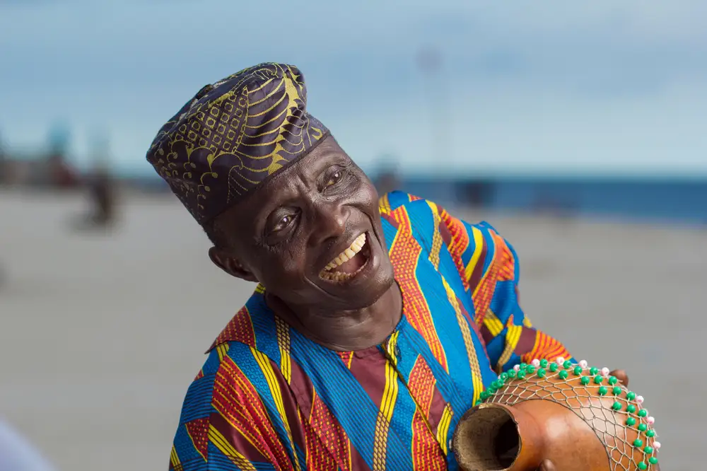 Laughing Man in Traditional Clothing Holding a Vase