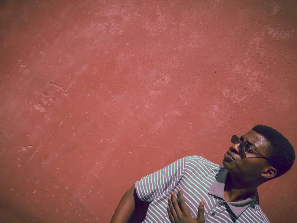 Man Striking a Pose in Front of a Wall