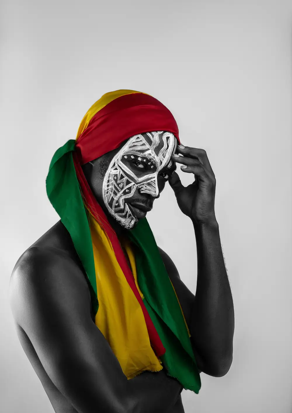 Man with face painting tying a Ghana flag.