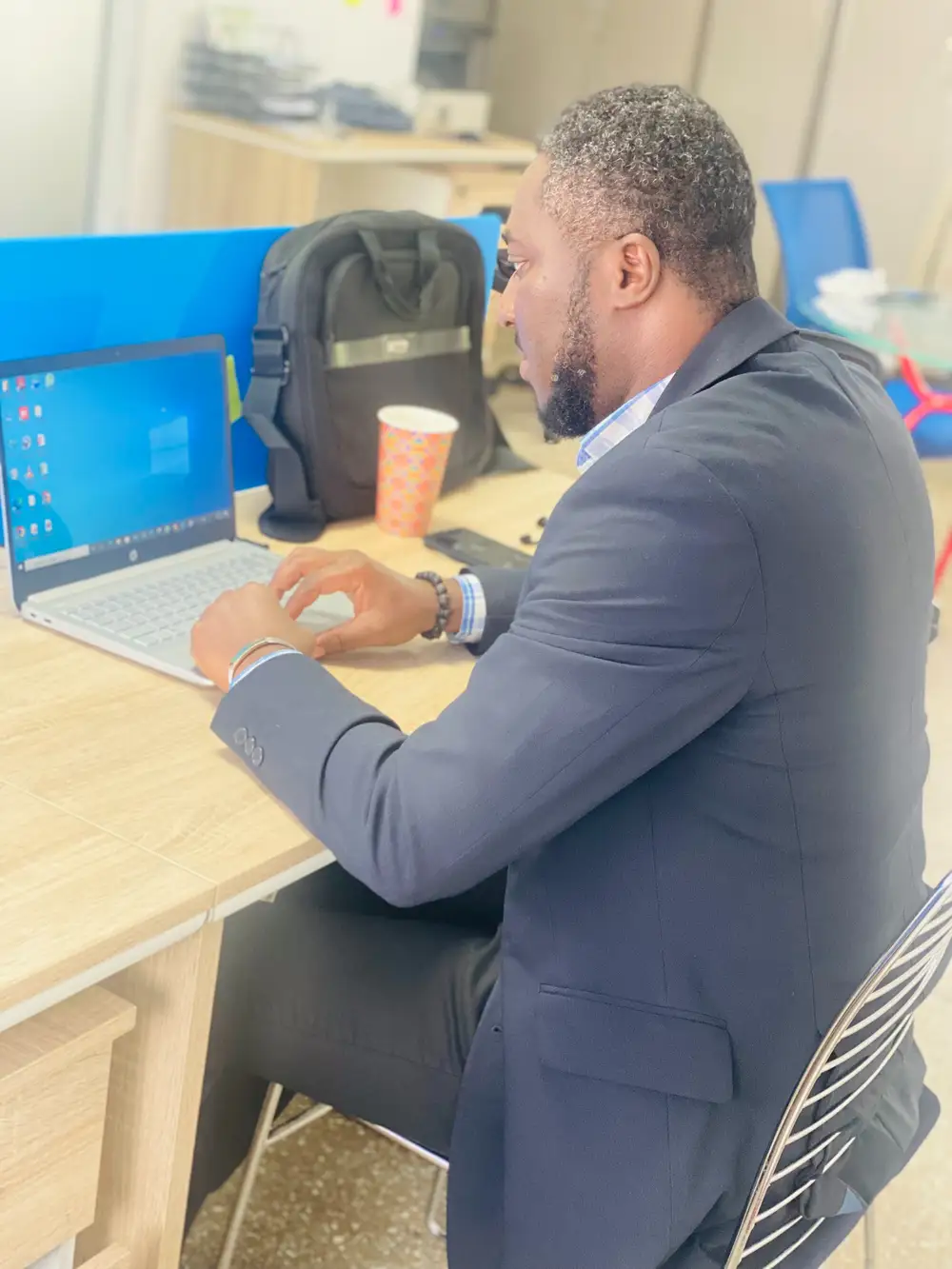 black man using hp laptop on an office table