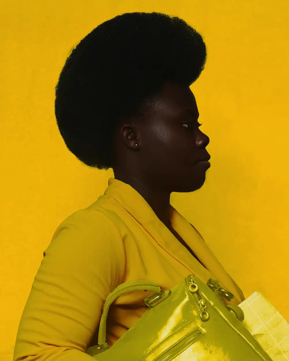 Black woman with hand bag on yellow.