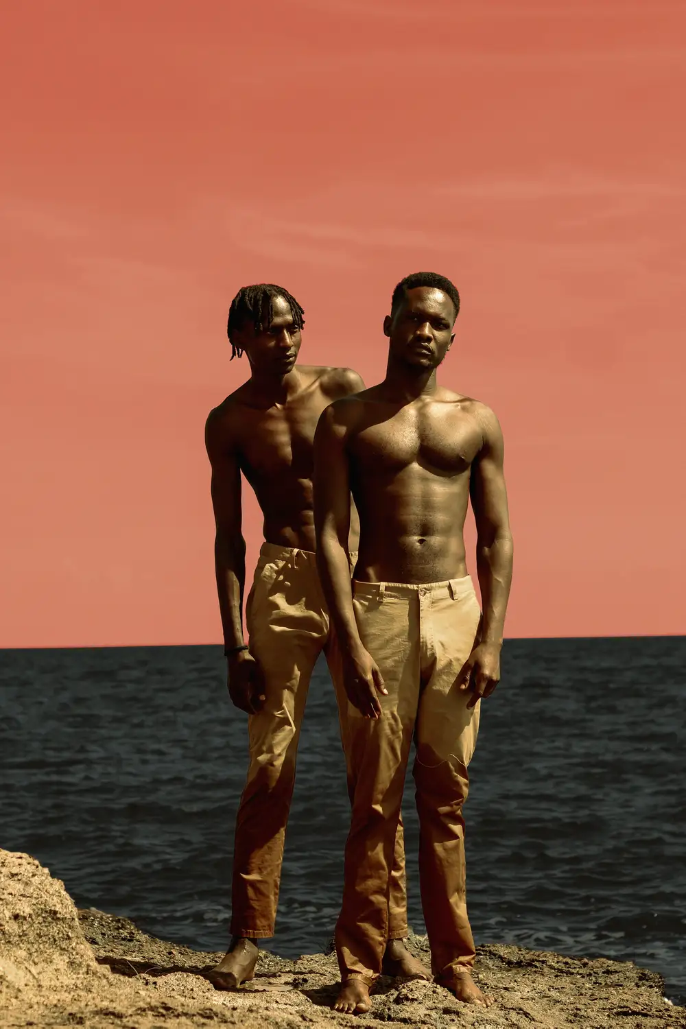 shirtless men posing near the ocean