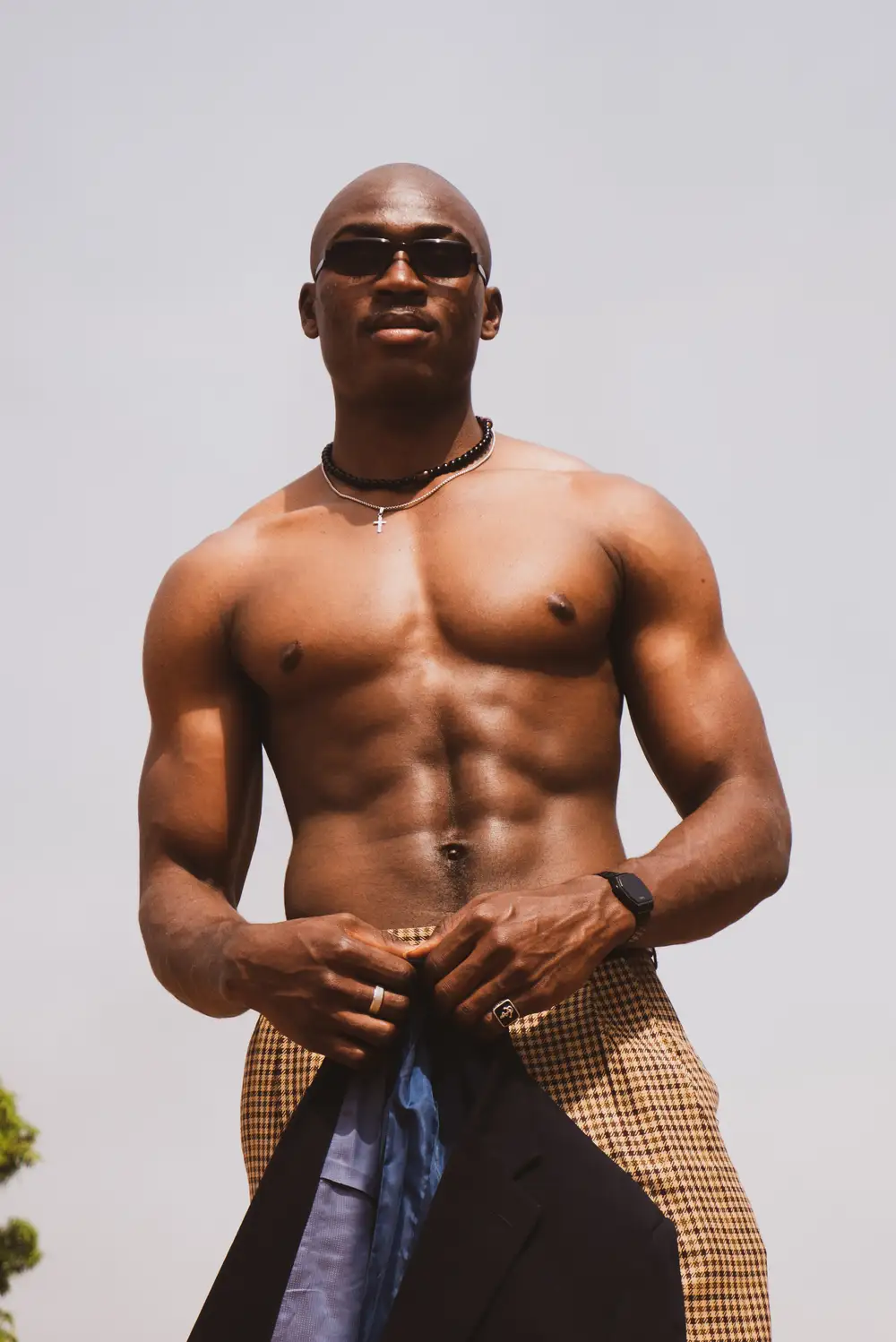 Cool Bare chested black man holding a suit