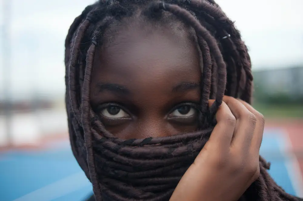 Young lady using her hair to cover her face