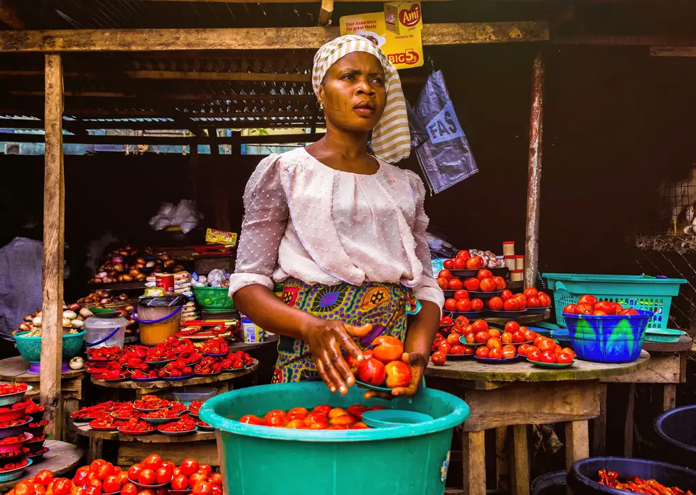 Market woman selling fresh pepper and tomatoes
