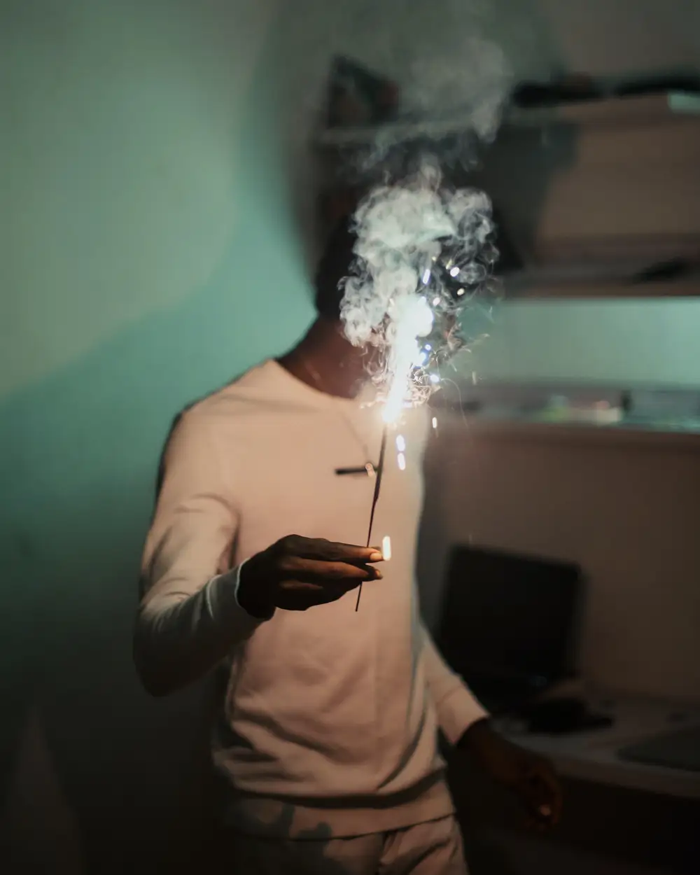 Black African man holding a sparkler to celebrate the new year.